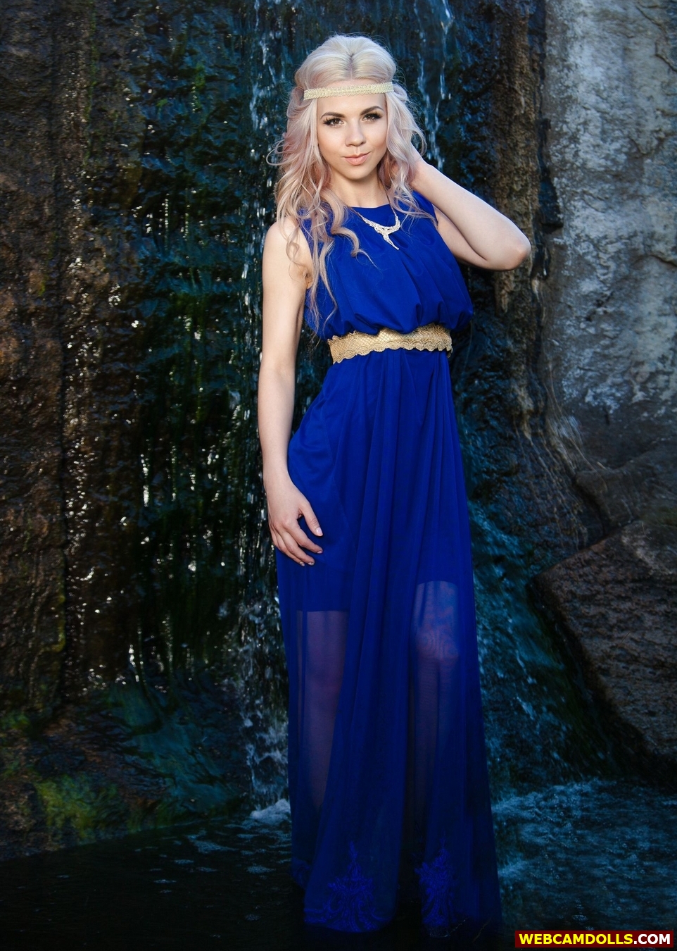 Blonde Girl standing in Water in Blue Long See Through Dress on Webcamdolls